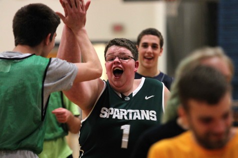Sophomore Zac Holman and Brennan high five after Brennan makes a basket