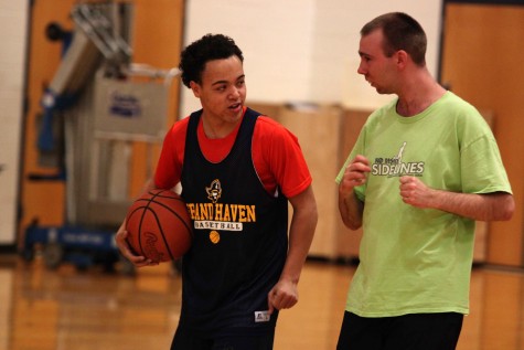 Senior Isaac Love jogs around the gym with Mikey during the warm up.