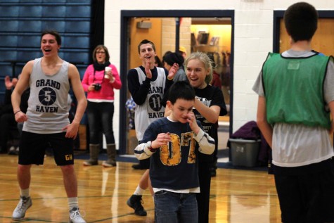 The team and parents cheer for Keegan after he makes a lay up