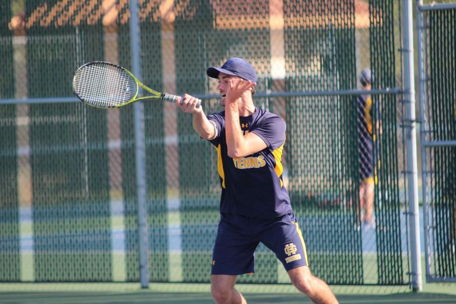 Senior Tristan Tongue hits a forehand shot in a home match against West Ottawa. Tongue and his partner, sophomore John Richardson, defeated their opponent  2-1.  