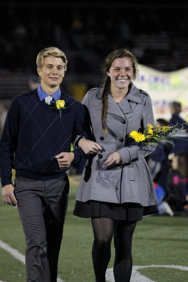 Seniors Connor Weber (left) and Hannah Kenny (right) link arms on the football field during the Homecoming game. While Kenny was named Homecoming queen, theres more to her than a crown. Kenny went on a mission trip in March, 2015 in Honduras. 