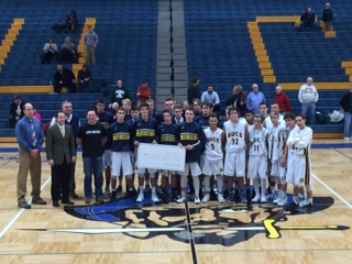 The boys basketball team stands with the check from their 24-hour basketball game fundraiser. They are donating $2,500 to the mental health campaign. 