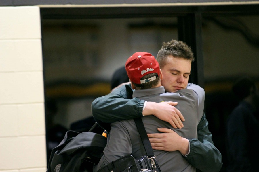 Senior Jason long hugs former assistant coach Bob Eidson after his last high school basketball season comes to a close with an emotional loss. 