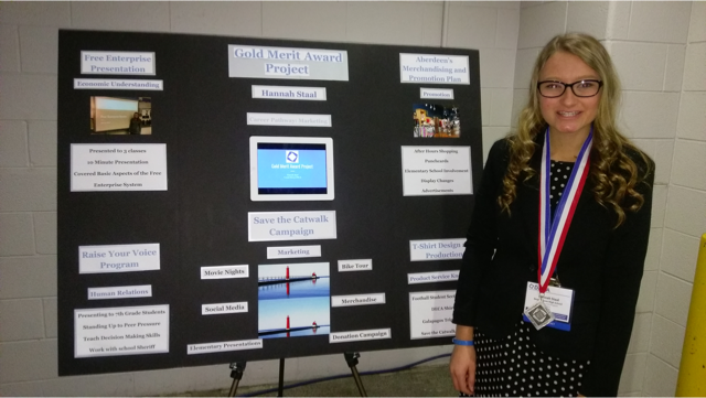 Senior Hannah Staal poses with part of her DECA project. Staal will attend the International Career Development Conference National Championship in California on April 26 for her achievements in DECA.