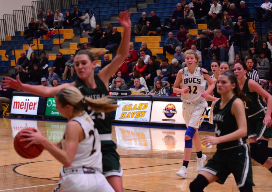 Senior Autumn Buikema looks to pass to junior Esther Byington while being heavily guarded by Forest Hills Central defenders. Buikema had a solid night with six points against the Fighting Scots.