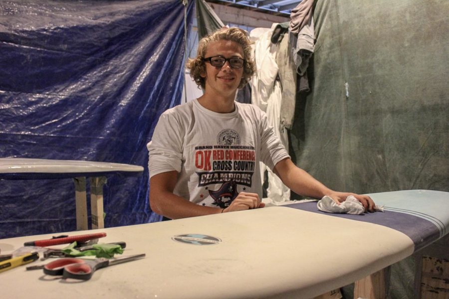Senior Nathan Wolffis works in his barn putting the finishing touches on his handmade surfboard 