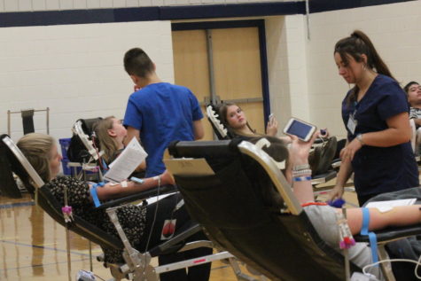 Students of science teacher Todd Diederichsen help out at recent blood drive in order to meet local quotas for blood.