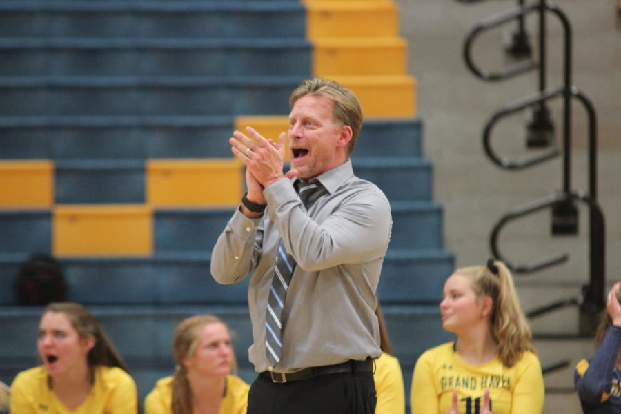 Head coach Aaron Smaka applauds his team as they made a good play at the senior night game.
