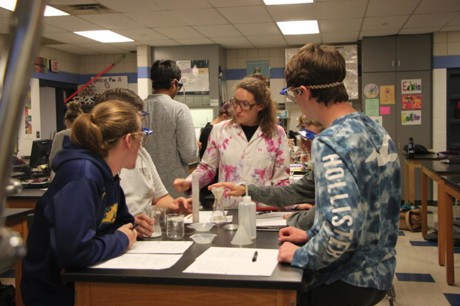 Chelsea Bender assists students with a lab in her chemistry classroom
