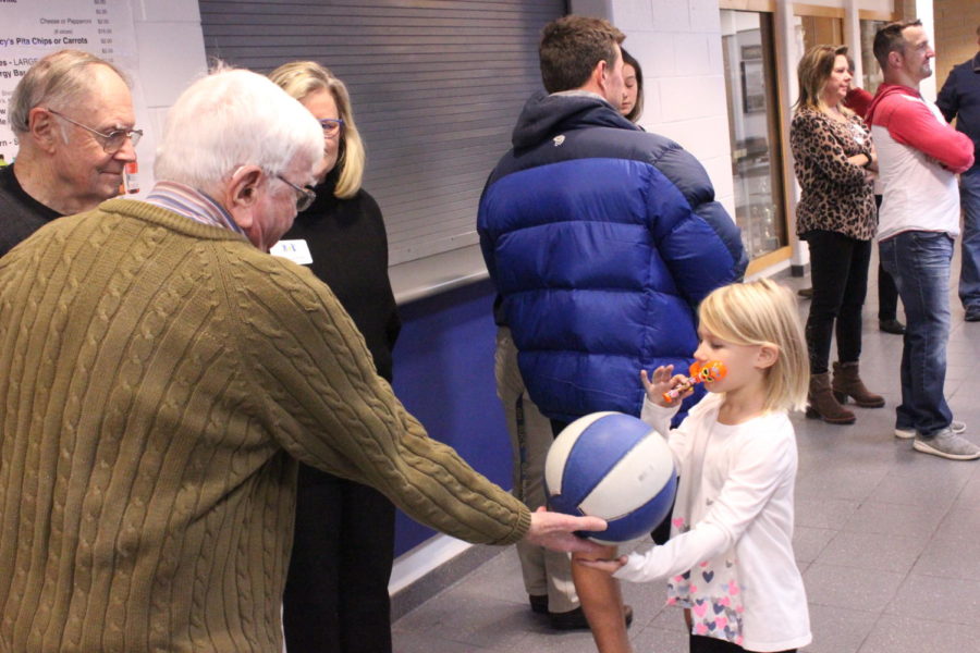 Dr. Angus picks up a run away ball and hands it back to the little girl playing with it. Even on a Saturday, the school was buzzing with activity.