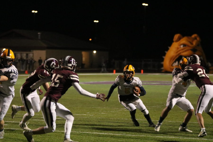 Senior quarterback Alex Kapala hangs onto the ball and quickly finds the gaps in Grandvilles defense. The Bucs ground game proved to be the deciding factor in the victory. 