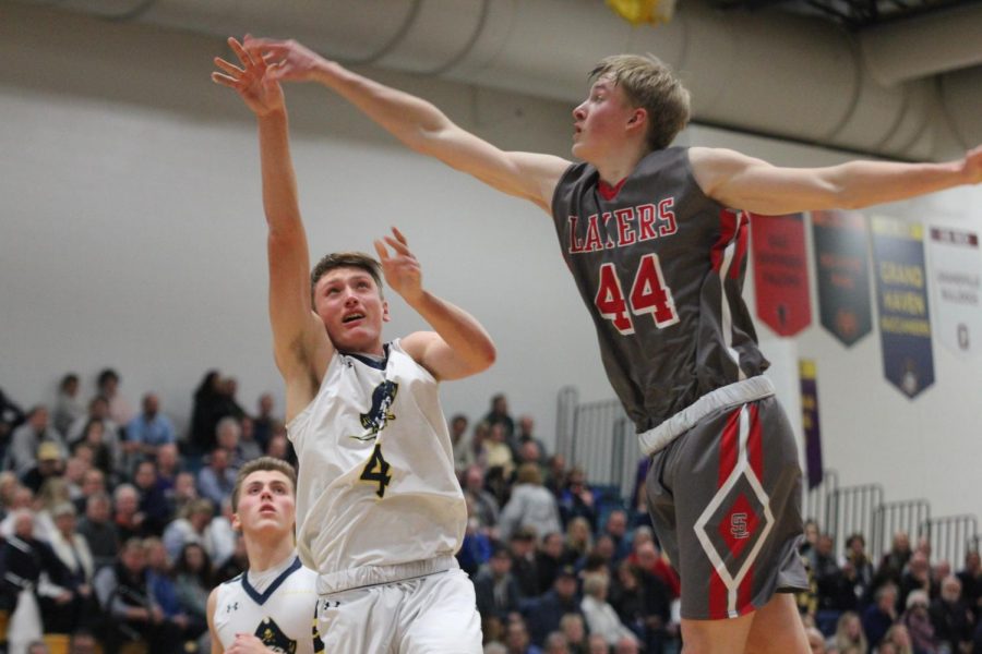 Senior Adam Strom takes the ball to the basket with a defender on his heels in the Battle of the Bridge game. The area around the basket was huge in this game as the squad fought for rebounds all night.