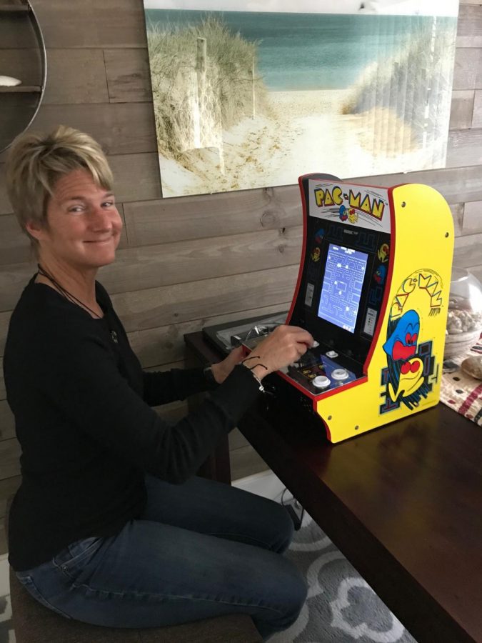 Special education teacher Melissa Richardson poses in front of her new Pac-Man game that she recently purchased. She likes to keep busy with fun activities she can involve her family in, like charades and other games.