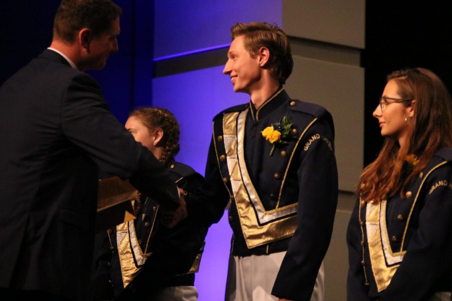 Trumpet leader Carson Bretz shakes band director Iain Novoselichs hand at the Bucs Last Blast earlier this year, a concert to celebrate senior members of the marching band.