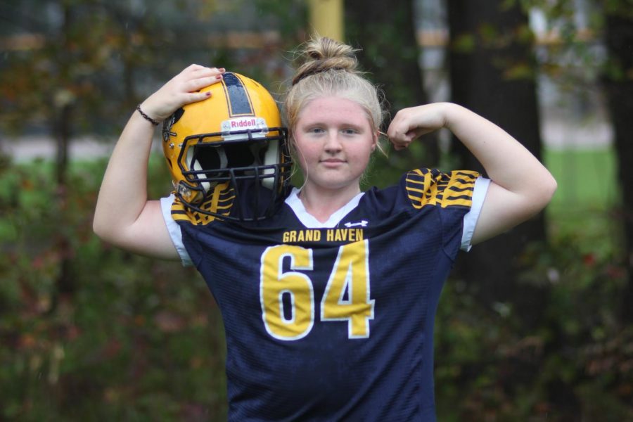 GIRL+POWER%3A+Freshman+kaitlyn+Gillard+shows+off+her+muscles+as+she+holds+onto+a+helmet.+She+started+playing+football+when+she+was+in+seventh+grade+and+is+currently+the+only+girl+in+the+Grand+Haven+High+School+football+program.+