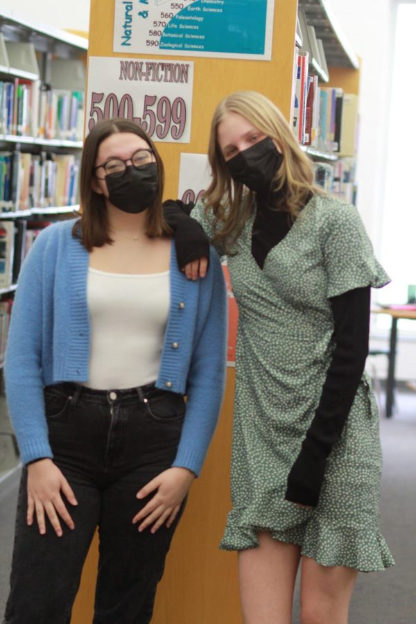 Kemppainen and Falaschini stand with each other in the library.