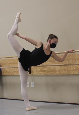 Meghan Brentana holds an attitude at the barre while warming up for the rest of class. 