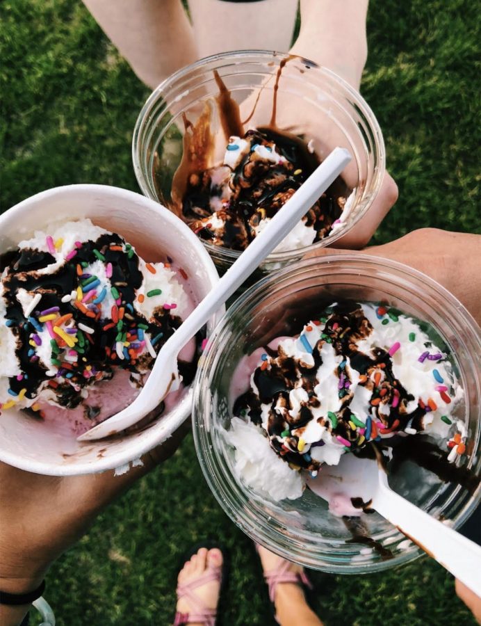 Ice cream sundaes with whipped cream, sprinkles and chocolate syrup. 