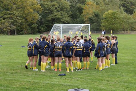 The rugby team huddles before their match against Grandville. The team had just finished practicing for the game ahead.
