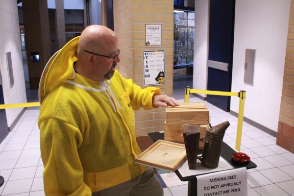 Matthew Pohl dresses as a beekeeper for Halloween. He uses a model of a bee hive to teach students about how bee keeping works.