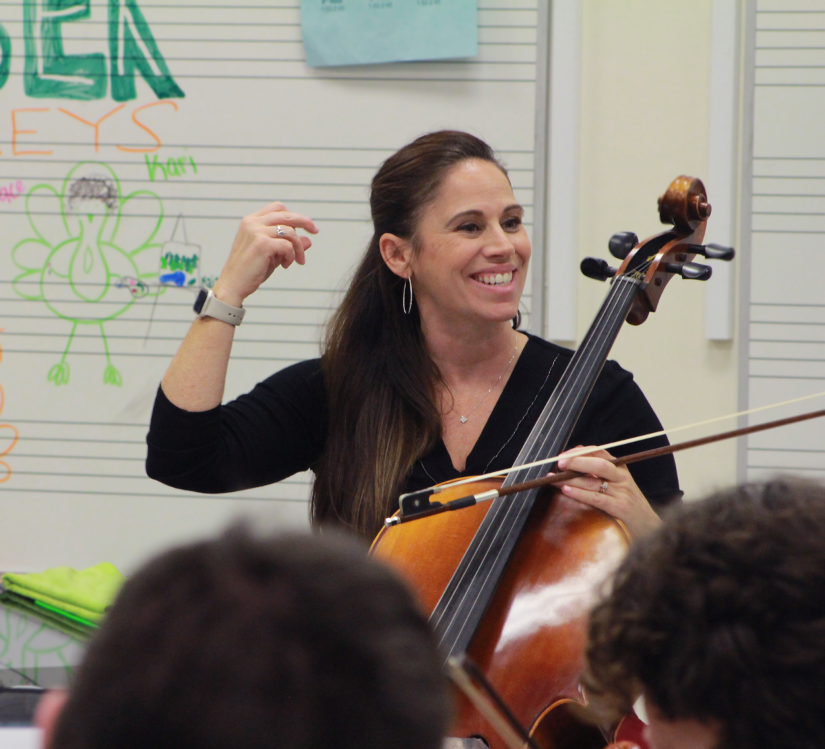 Orchestra teacher Melissa Meyers snaps to keep the rhythm. Her students play in sync forming a harmony that resonates down the music wing.