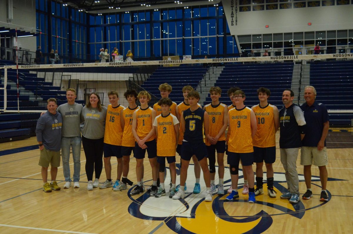 The+Boys+Volleyball+team+lines+up+for+photos+after+winning+their+state+semifinals+match+and+moving+onto+the+finals.+The+Bucs+will+be+playing+against+Hudsonville+for+the+third+year+in+a+row.