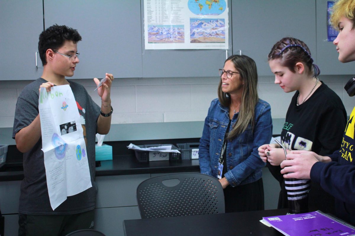 Freshman DeAnthony Mendoza presents to fellow classmates Karl Hopkins and Sky Sibley as well as assistant teacher Amy Jeltema.