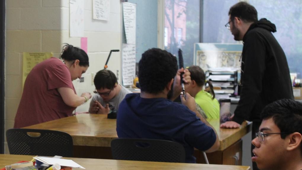 Teaching assistant Amanda Commons (left) speaks to students in Xavier Golden's Adaptive Art class. She can be found working in multiple special education classrooms during the day.