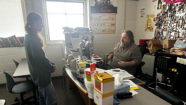 Sophomore Sarah Ritter, an in-person student, seeks guidance from AP History teacher Mark Robertson on her project, highlighting the vital role of mentorship in academic success. As students at Grand Haven consider the shift to online education, moments like this emphasize the importance of face-to-face interactions in fostering social connections.