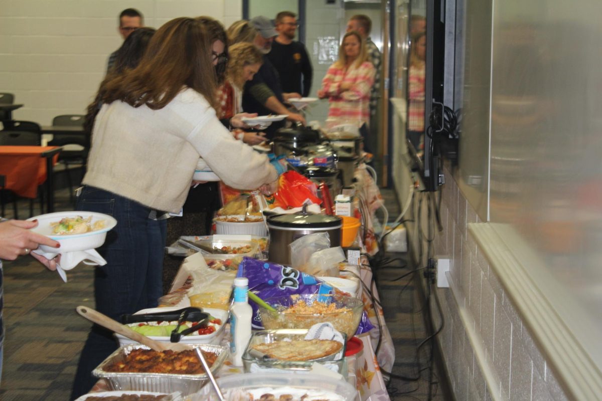 Teachers grab food from the staff potluck in the LGI on Tuesday Nov. 26. This encourages togetherness and shows appreciation for staff.